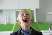 Een lachende jongen in de behandelstoel